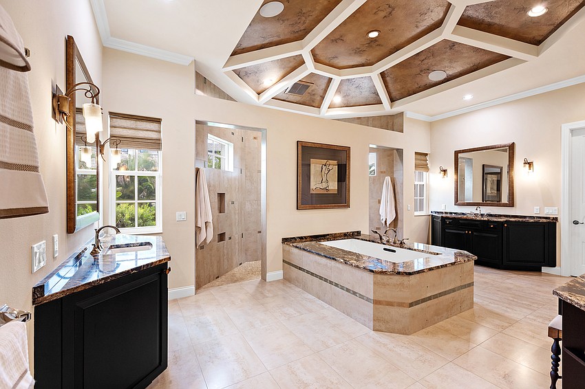 The expansive primary bath is full of unexpected luxuries, including a Jacuzzi tub and a walk-in shower with a selection of shower heads.