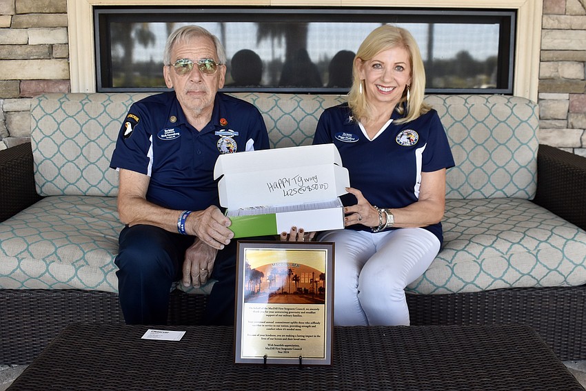 Rich Greenberg and Peggy Hufford hold 425 Publix gift cards that will be delivered to MacDill Air Force Base for Thanksgiving.