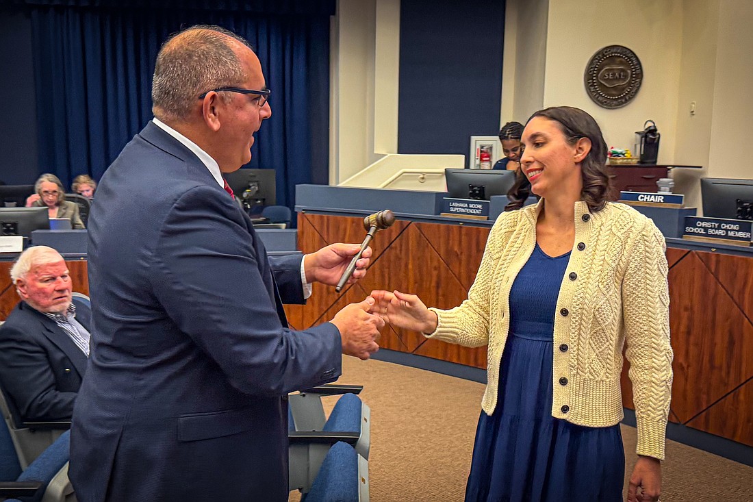 Will Furry hands Christy Chong the gavel after Chong was sworn in as the Flagler County School Board's new chairwoman. Courtesy photo by Don Foley/Flagler Schools