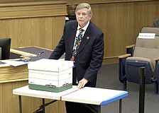 Sarasota County Commissioner Mark Smith uses a table to illustrate a beachfront lot and a box to illustrate building size and height to argue for a Comprehensive Plan change for voluntary redevelopment.