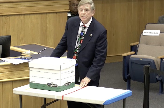 Sarasota County Commissioner Mark Smith uses a table to illustrate a beachfront lot and a box to illustrate building size and height to argue for a Comprehensive Plan change for voluntary redevelopment.