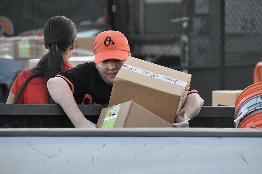 Sarah Baer loads boxes into a trunk.