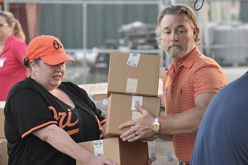 Sarah Baer and Carl Reynolds of Carl Reynolds Law work together to load boxes.