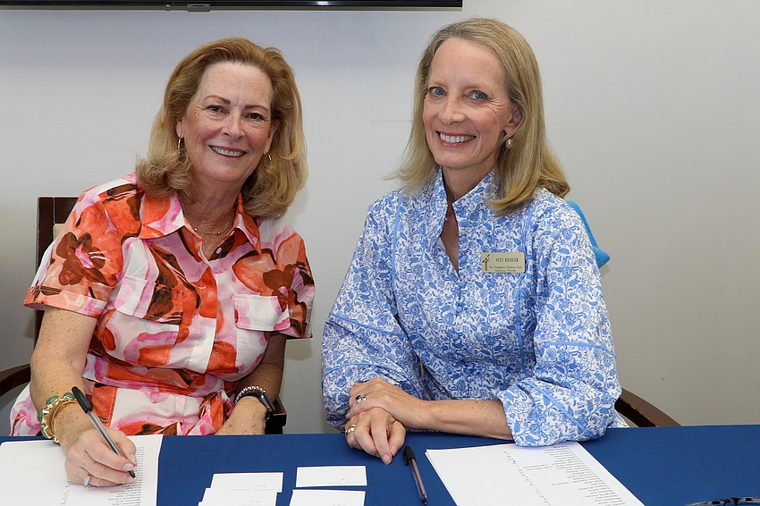 Julie Delaney and Suzy Kessler check guests in at arrival.