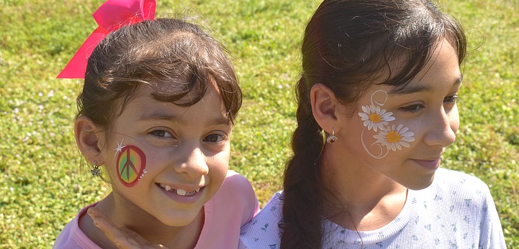Lakewood Ranch sisters Mariapaz Ritter, 7 and Analia Ritter, 12, got their faces painted by Akiko Graphics at the at Greenbrook Adventure Park. Mariapaz chose a peace sign because "paz" the last part of her name means peace in Spanish and Analia chose daisies because they are her favorite flowers.