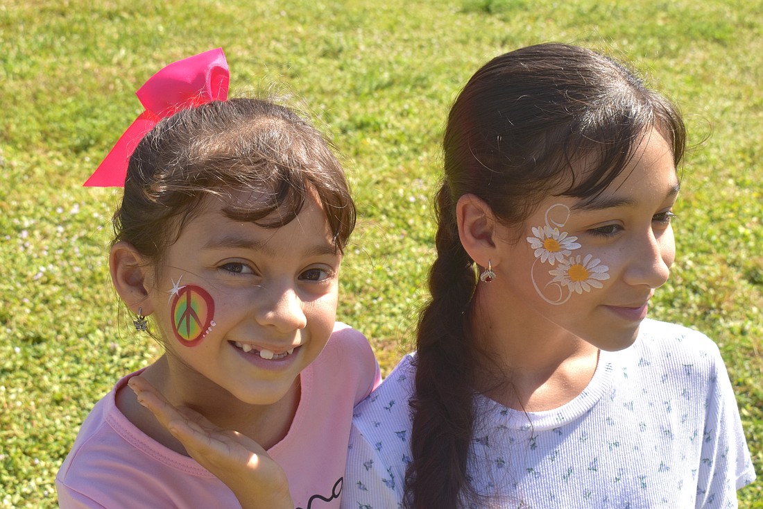 Lakewood Ranch sisters Mariapaz Ritter, 7 and Analia Ritter, 12, got their faces painted by Akiko Graphics at the at Greenbrook Adventure Park. Mariapaz chose a peace sign because "paz" the last part of her name means peace in Spanish and Analia chose daisies because they are her favorite flowers.