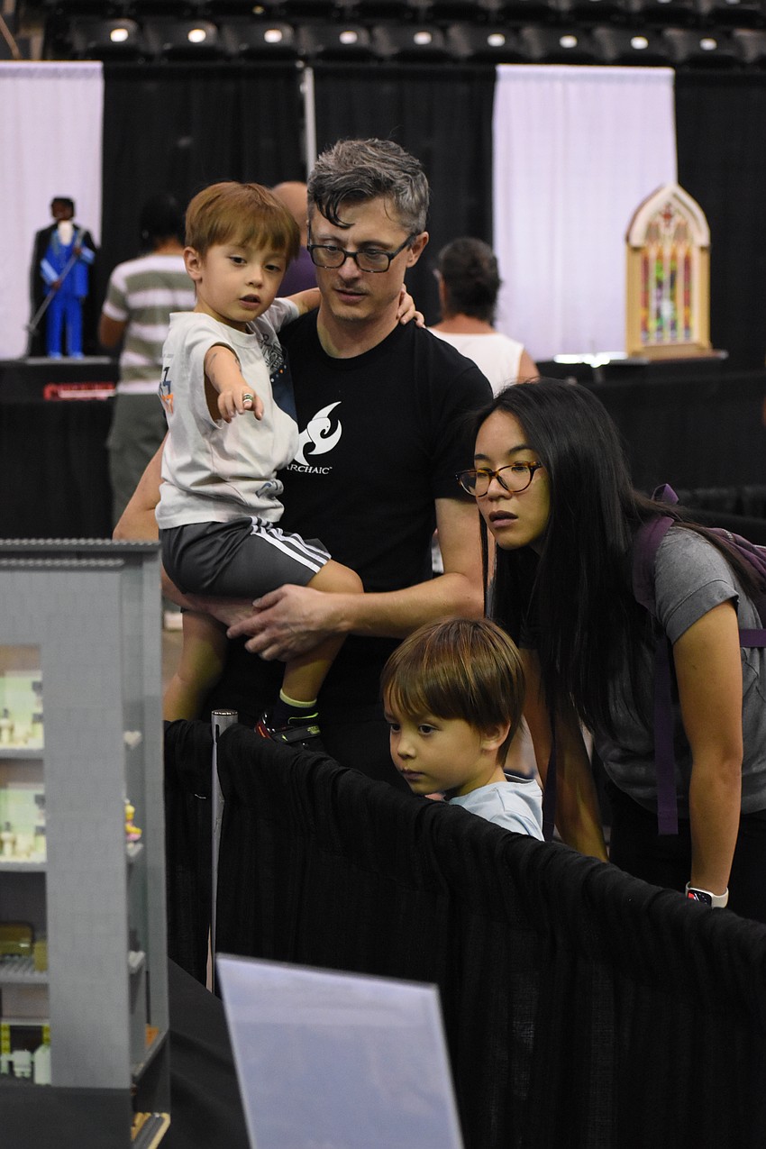 Kit Abrams, 4, James Abrams, Jason Abrams, 6, and Catherine Abrams view one of Mark Lorah's Lego creations.
