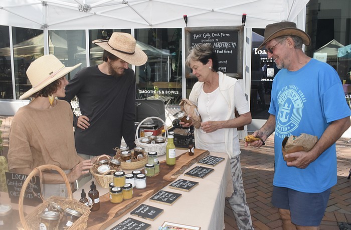 Miriam Cornell and James Garlanger of Bear Gully Creek Farms talk with Cornell's mother, Sharon Cornell, and Jim Sroka.