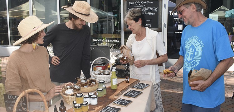 Miriam Cornell and James Garlanger of Bear Gully Creek Farms talk with Cornell's mother, Sharon Cornell, and Jim Sroka.