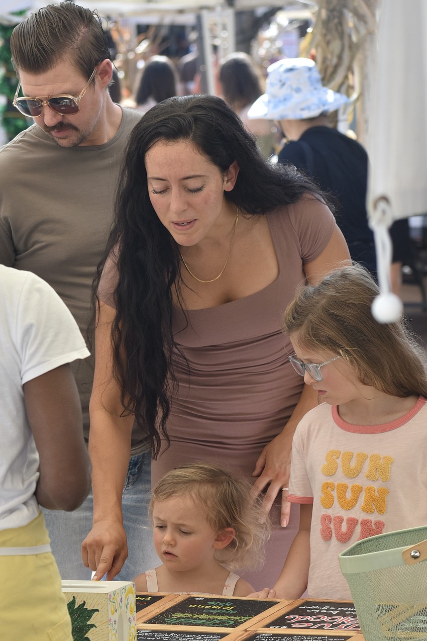 Dustin and Hailey Drost, Aspen Drost, 3, and Phoenix Drost, 7, look over a series of juices.