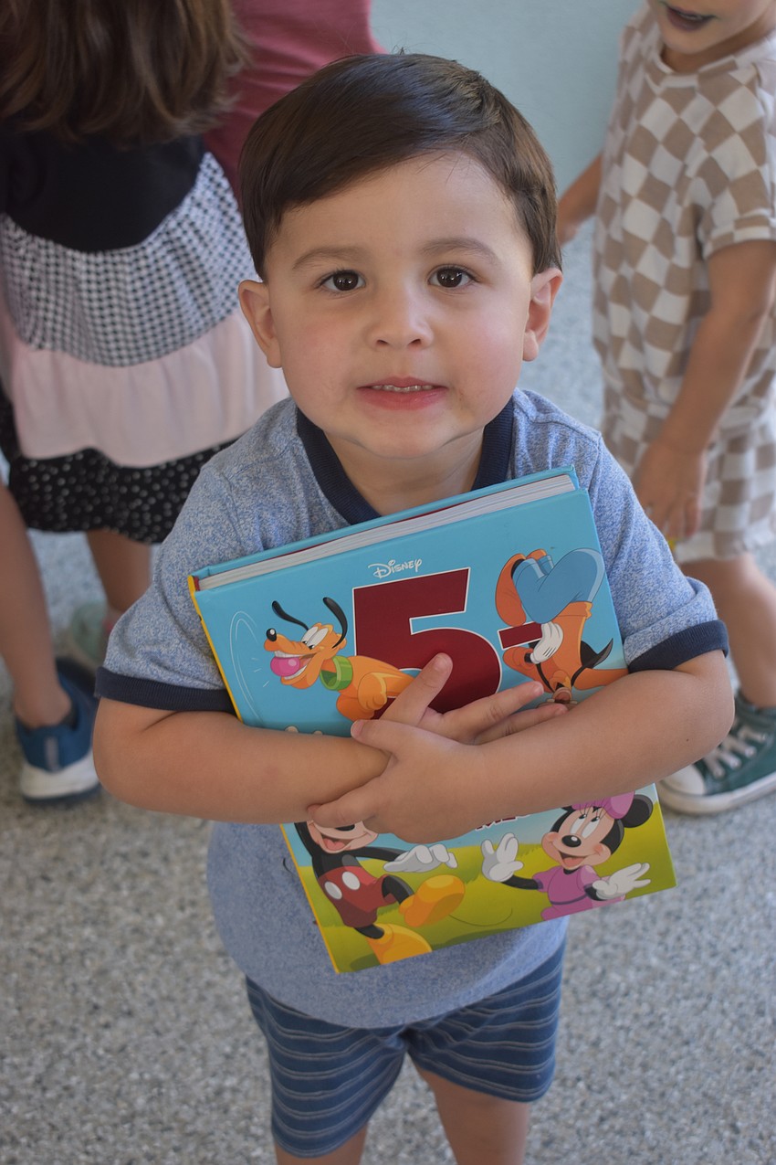 Greenbrook's Liam Martinez, 3, is eager to take home his Disney themed book from the new Little Free Library inside the pavilion at Greenbrook Adventure Park.