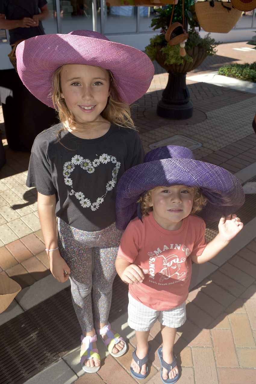 Zaya Robinson, 8, and Levin Robinson, 3, try on some of the hats at Big Top Baskets.
