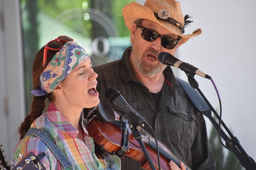 Sara Stovall and Doug Conroy members of the folk/bluegrass band Passerine, which performed at the market, sing for attendees.