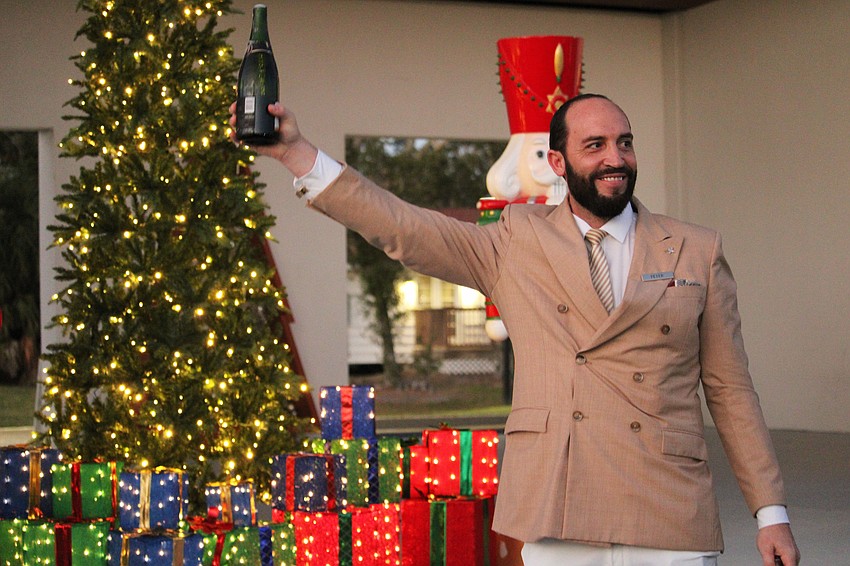Peter Forsyth from The St. Regis Longboat Key Resort signals for the lighting of the Christmas tree with a champagne sabrage at Light Up Longboat on Nov. 22 at the Town Center Green.