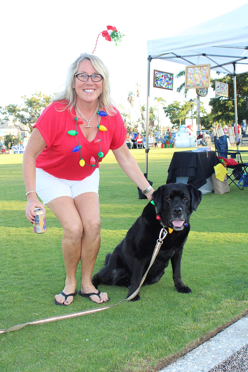 Natalie Solomon and her dog, Mack, wear coordinating necklaces of Christmas tree lights to Light Up Longboat.