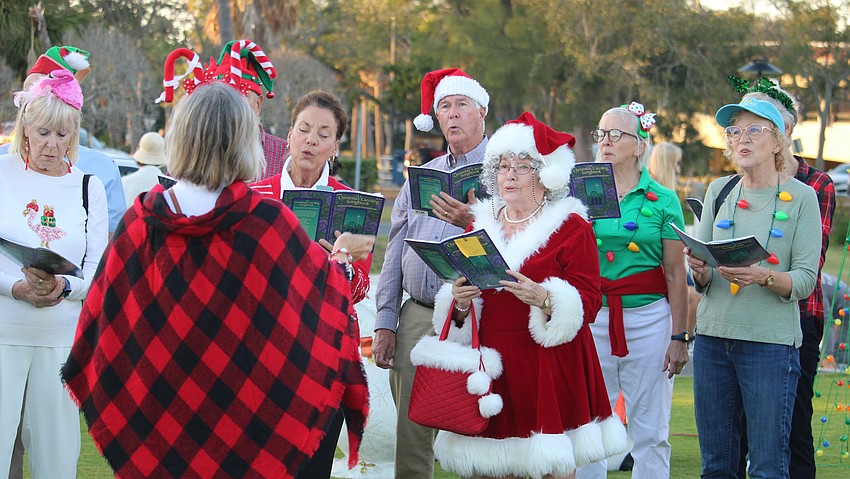 Margaret Moore, dressed as Mrs. Claus, carols with fellow volunteers from Christ Church of Longboat Key. She later won the raffle the Rotary Club of Longboat Key held to support HOPE Family Services in Bradenton.