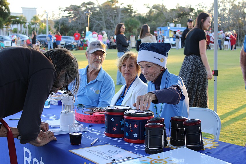 Janet Shapiro with the Rotary Club of Longboat Key helps run the raffle booth collecting donations for HOPE Family Services in Bradenton.