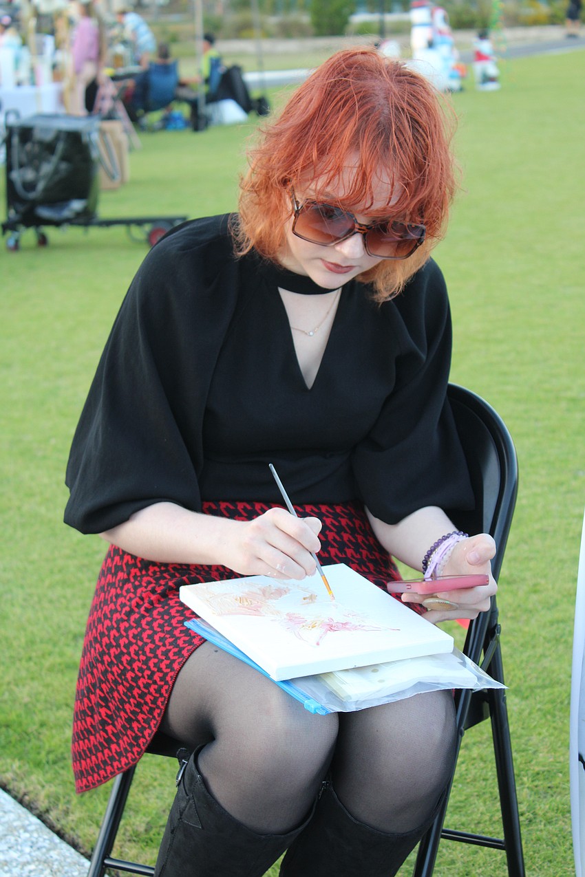 Local artist Jackie Williams does a live painting demonstration as part of the festive fun of Light Up Longboat.