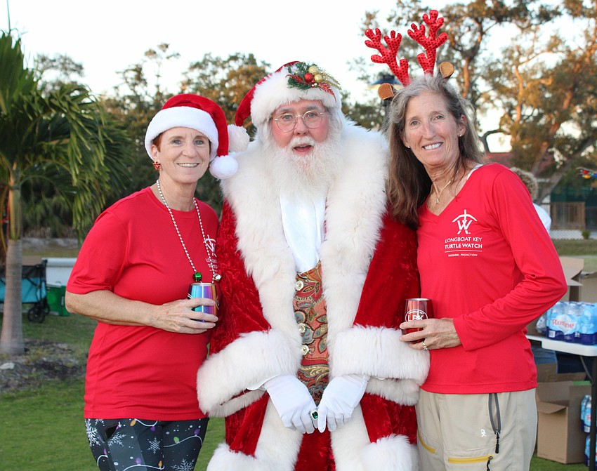 Carlyn Vigil and Cyndi Seamon snap a picture with Santa Claus before he makes his way to the Karon Family Pavilion for the tree lighting at Light Up Longboat.