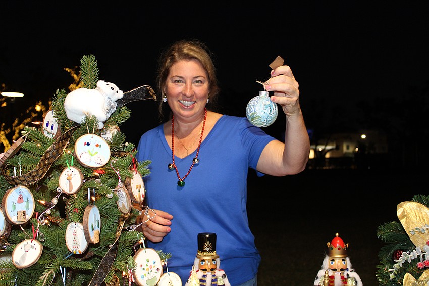 Valerie Nelson from Le Gardenia Bleu, recent winner of the Longboat Key Chamber of Commerce's Emerging Business of the Year Award, shows departing guests their available holiday ornaments.