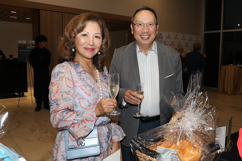 Sally Ling and her brother Steven Ling enjoy champagne and silent auction items.