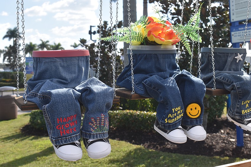 At the Shorty's & Gifts booth, there are various planters made of wood to mimic legs and feet that sit on swings.