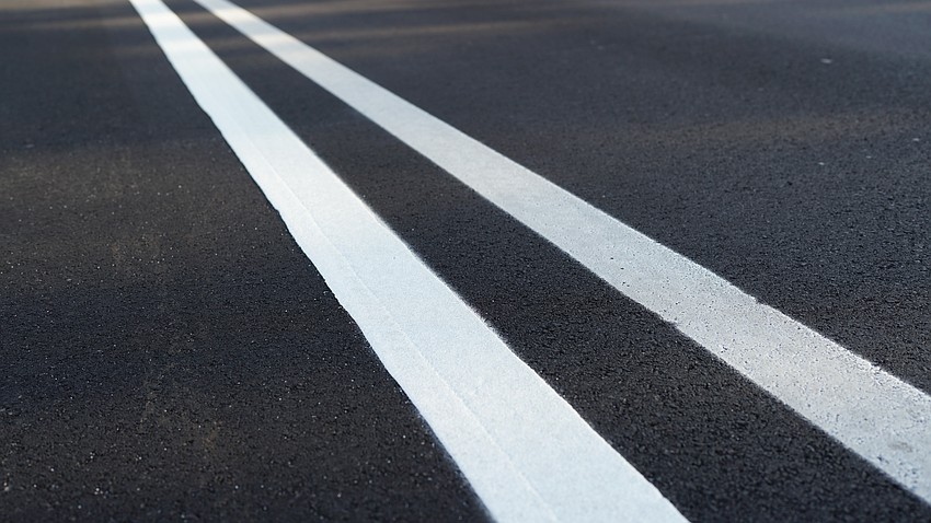 The striping has begun on the Country Club Shores turn lane project. The left line shows the permanent thermoplastic striping which is more resilient and reflective than the typical paint, on the right.