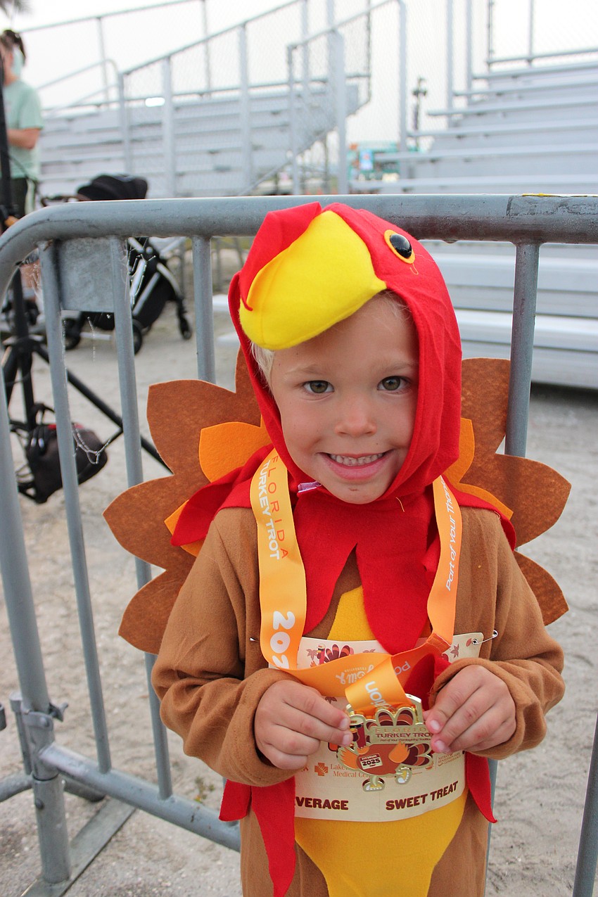 Bozeman, Montana's Tripp Porter shows off the medal he won for participating in the 4-5 kids run during the Florida Turkey Trot at Nathan Benderson Park.