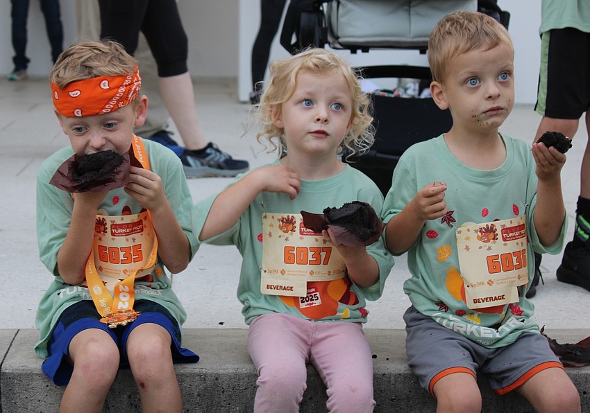 Mason, Isla, and Knox McGough of Sarasota were enjoying the muffin treats given to runners after the kids races at the Florida Turkey Trot at Nathan Benderson Park.