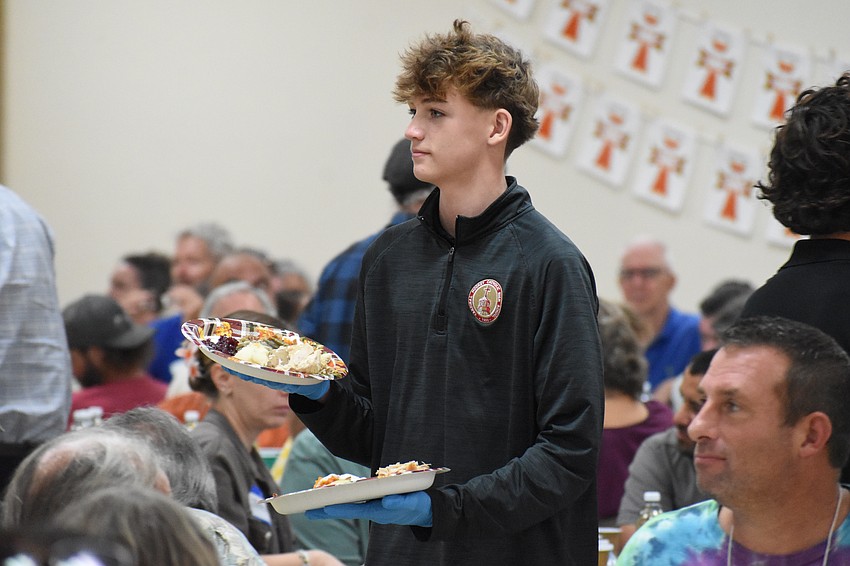 Cardinal Mooney High School sophomore Grant Yeagley serves Thanksgiving dinners.