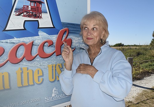 Cynthia Jordan poses by the "No. 1 Beach in the USA" sign.
