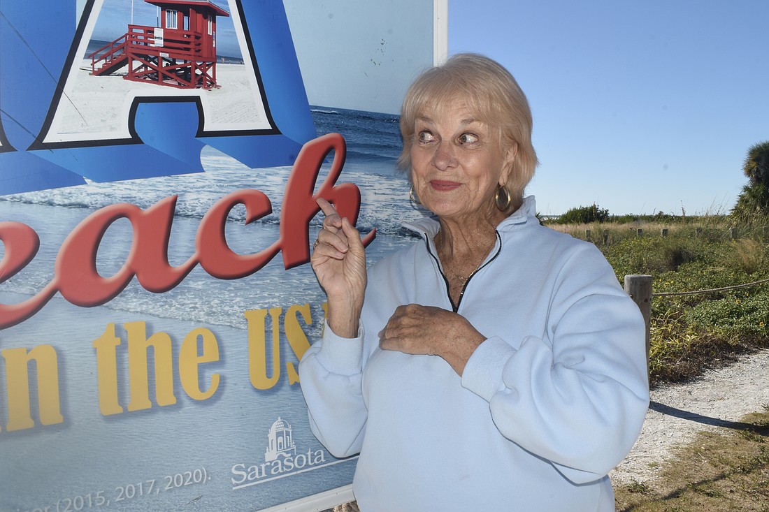 Cynthia Jordan poses by the "No. 1 Beach in the USA" sign.