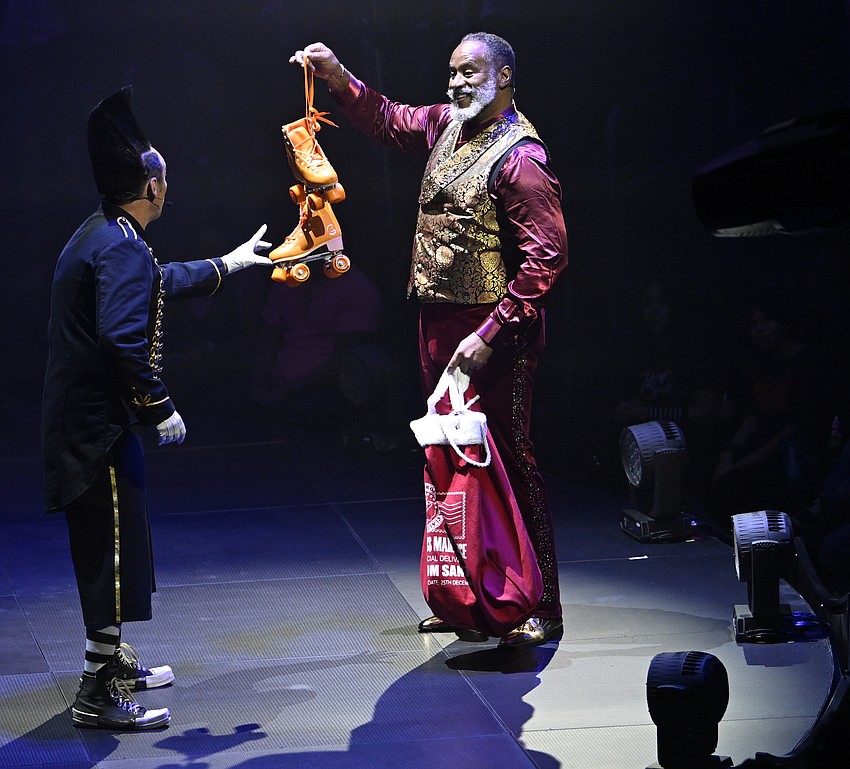 Clown Johnny Rockett gets a pair of roller skates from Ty McFarlan in 