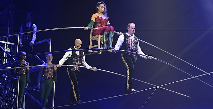 Lijana Wallenda perches on a chair balanced on a shoulder bar carried by her brother Nik Wallenda and Paul Matthew Lopez in the "Wonderland: Believe" circus, which runs through Jan. 4 in a big top near the UTC Mall.