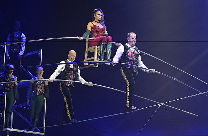 Lijana Wallenda perches on a chair balanced on a shoulder bar carried by her brother Nik Wallenda and Paul Matthew Lopez in the "Wonderland: Believe" circus, which runs through Jan. 4 in a big top near the UTC Mall.