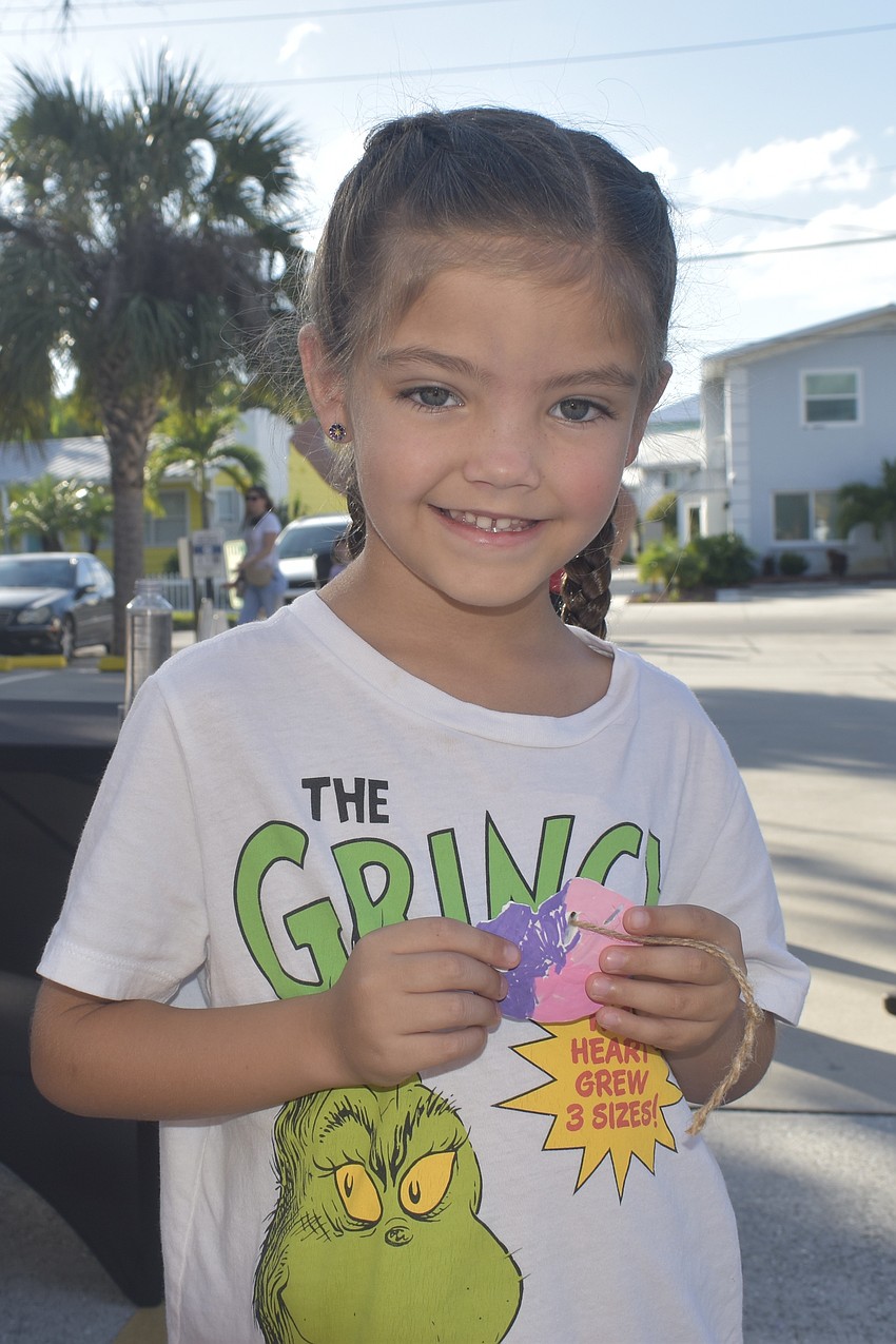 Tilly Stokes, 5, holds a sand dollar she painted at the Siesta Key Chamber of Commerce.