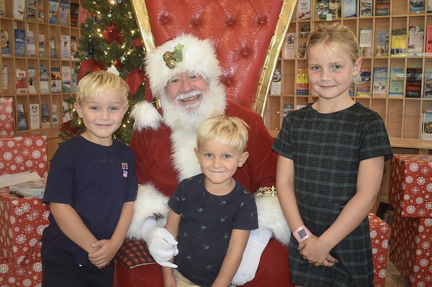Richard Benoit, 5, Samuel Benoit, 3, and Caroline Benoit, 7, meet Santa Claus.