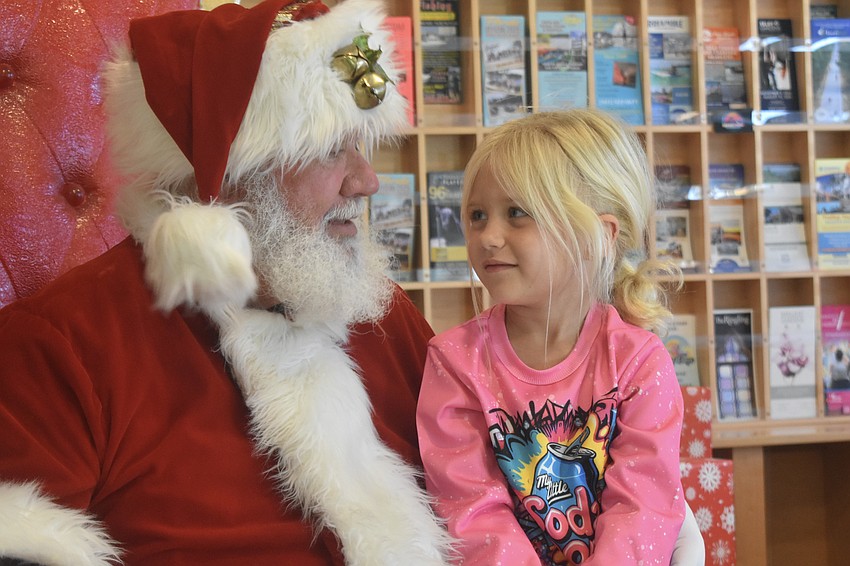 Marlyn Carlburg, 5, talks with Santa.