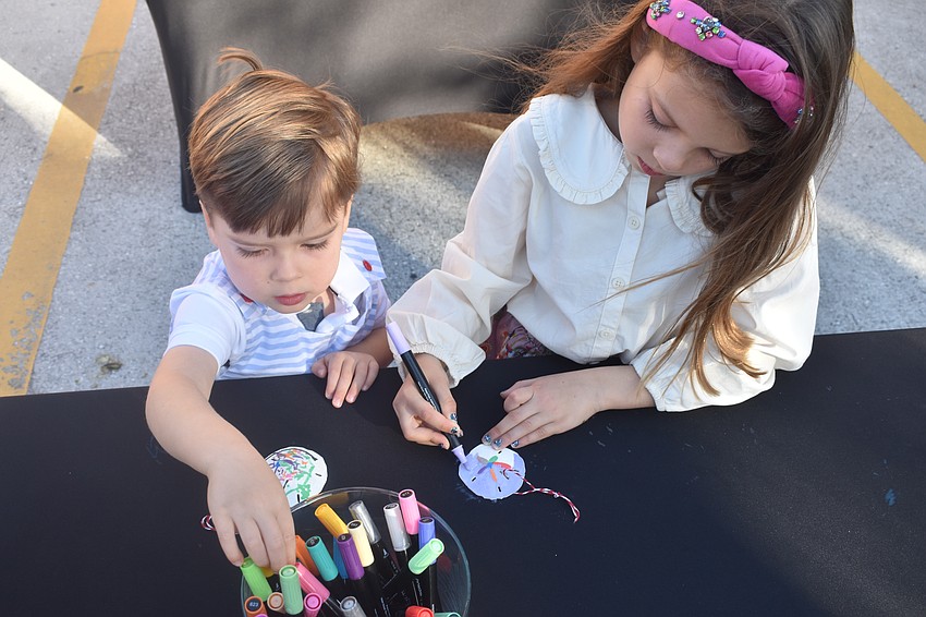 Griffin Palmer, 3, and Galena Palmer, 7, color sand dollars.