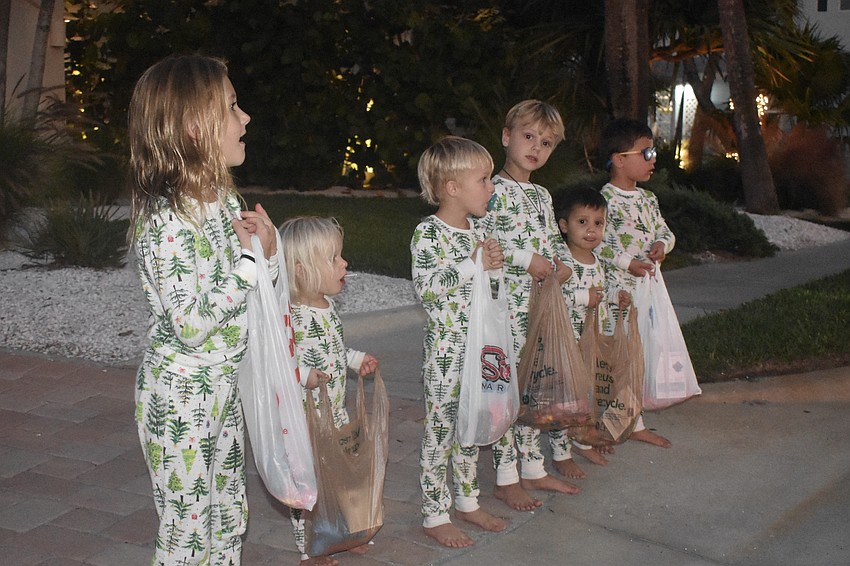 Kate Hopen, 7, Anna Hopen, 2, Leo Hopen, 4, John Hopen, 5, Mo Tribedi, 3, and Aayan Tribedi, 5, await candy along the parade route.