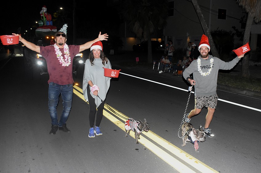 Hunter, Julie, and Nickolas Mechigian represent Siesta Charters, walking with pups Maui and Largo.
