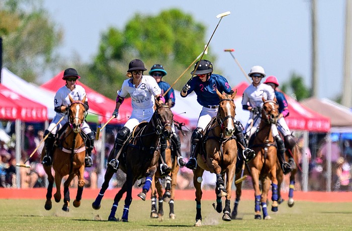Mica Sarraco (white) battles with Olivia Uchiritz (blue) during a polo match at Sarasota Polo Club.