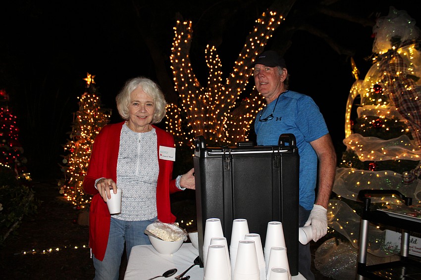 Laurel Maul and David Stone prep the hot chocolate for attendees at the opening ceremony of Christmas in the Garden before the fun comes to a close for the evening. The garden will remain open throughout December.