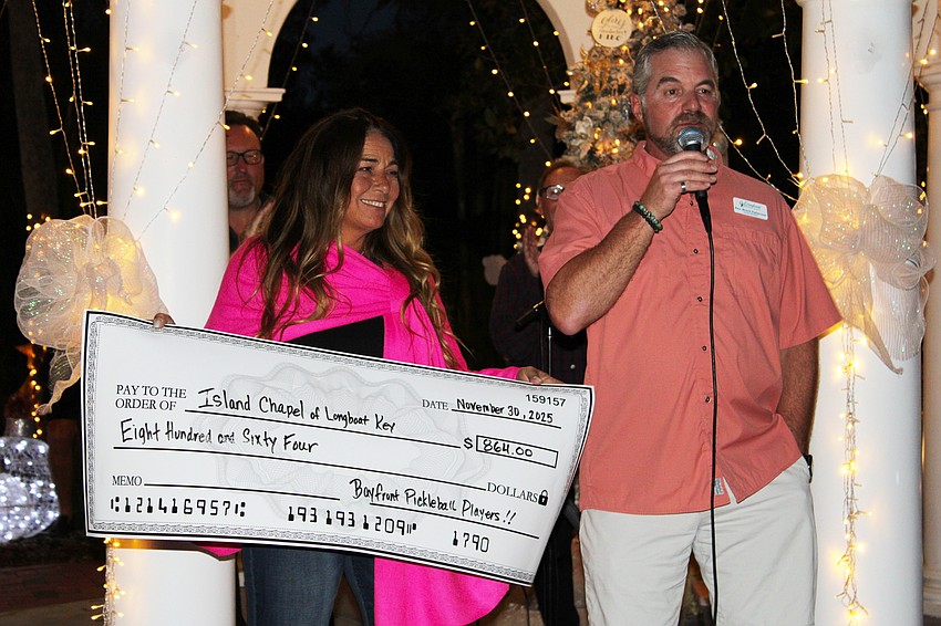 Bayfront Park pickleball player Karen Vito presents a check to Longboat Island Chapel, host of Christmas in the Garden, from fellow players hoping to support the holiday fun.