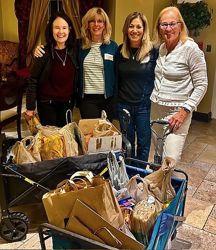Mary Vamos, Joanne Murphy, Fran DeMartin and Joani McCullough at Yacht Harbor condos with wagon loads of nonperishable food collected for Grace Community Food Pantry. Courtesy photo
