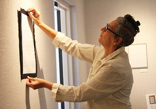 Artist JC Wayne hangs the ninth and final piece in her series "Atomic Universe," the latest installation at All Angels by the Sea Episcopal Church. The display will be up throughout the holiday season.