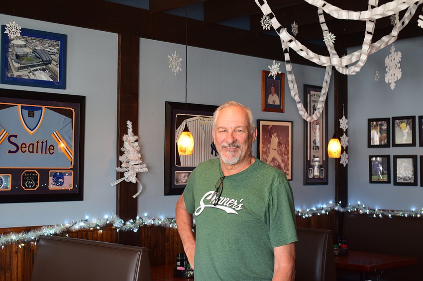 Shane Rawley poses for a photo in one of the seating areas at Shaner's Pizzeria. Since opening in 1991, his establishment has served up thin-crust pizza, wings, salads and more.