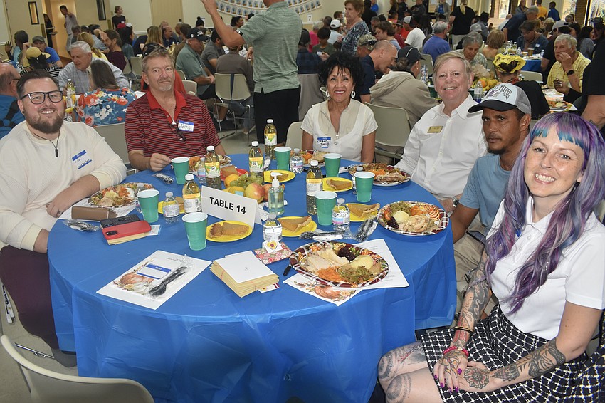 Hudson Stutz, John Urban, Esther Smith and her husband, County Commissioner Mark Smith, Julio Angel and Megan Howell, sit around a table together.