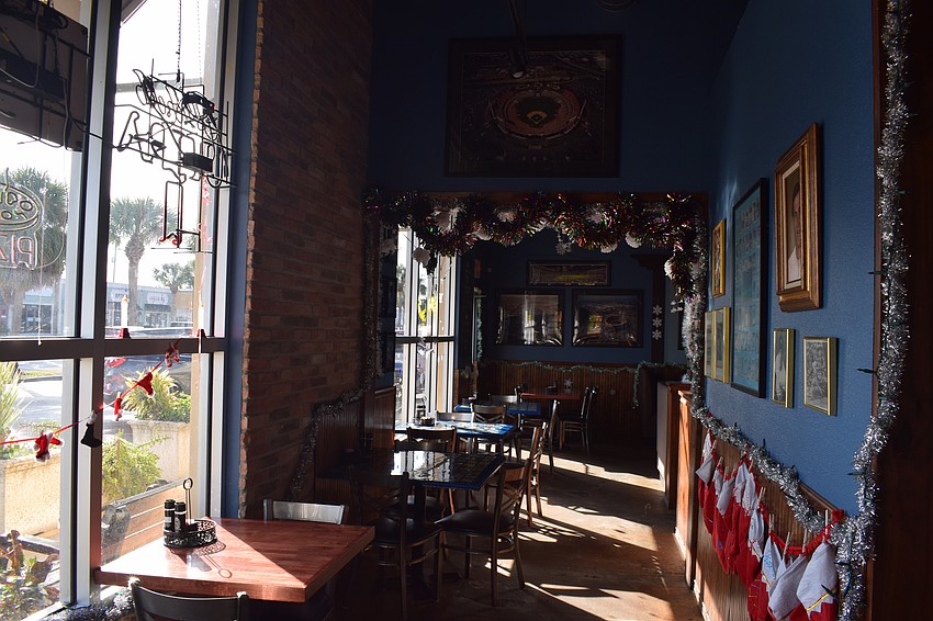 One of the halls at Shaner's Pizzeria is pictured. Along with framed photos and memorabilia on the walls, there are neon signs of MLB team logos and baseball cards lining the bar.