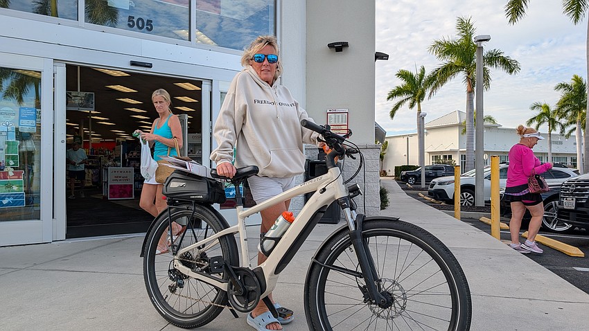 Patricia Lopez rides her specialized e-bike from the north end of the Longboat Key to CVS to pick up essentials Monday, Dec. 1.